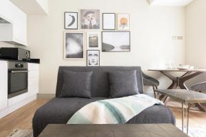 The New Bond Street Loft - Modern & Central 1BDR في لندن: غرفة معيشة مع أريكة وصور على الحائط