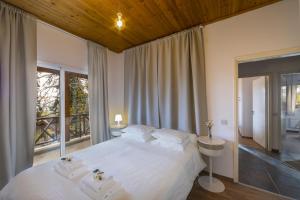 a bedroom with a large white bed and a window at Platres Forest View Cottage in Platres