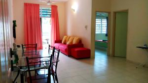 a living room with a red couch and a table at Jeffrey Homestay B @ Lost World of Tambun in Ipoh