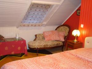 a bedroom with a bed and a chair and a window at Kernel Bihan in Pont-lʼAbbé