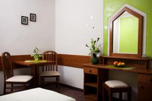 a room with a mirror and a table and chairs at Gästehaus Stroitz in Drobollach am Faakersee