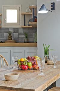 a wooden table with a bowl of fruit on it at Kalimera Karpathos Exclusive Villas in Afiartis