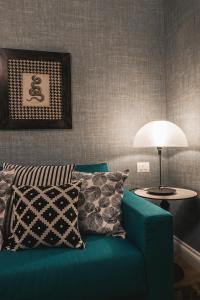 a living room with a blue couch and a lamp at Florence Prestige Apartments ZANOBI 55 in Florence