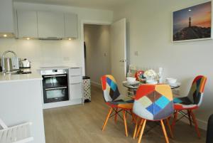 a kitchen and dining room with a table and chairs at Byron, Woolacombe 7 in Woolacombe