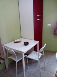 a white table with two chairs and a bowl on it at Bed And Breakfast Priscilla in Regalbuto +16 photos