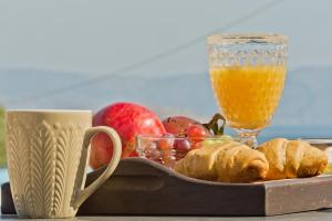 a tray of fruit and a glass of orange juice at Kalimera Karpathos Exclusive Villas in Afiartis
