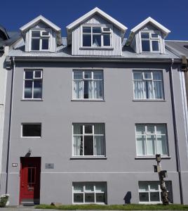 a white house with a red door at Nest Apartments in Reykjavík