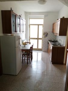 a kitchen with a table and a white refrigerator at Fra il MARE e la SILA in Cerenzia