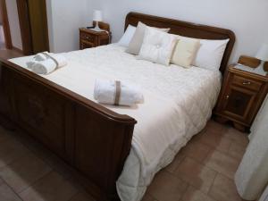 um quarto com uma cama grande com lençóis brancos e almofadas em Fra il MARE e la SILA em Cerenzia