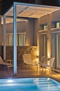 a patio with chairs and a swimming pool at Kalimera Karpathos Exclusive Villas in Afiartis