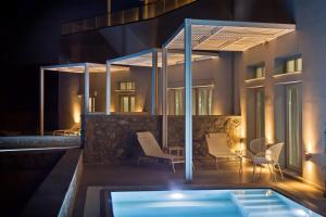 a villa with a swimming pool at night at Kalimera Karpathos Exclusive Villas in Afiartis