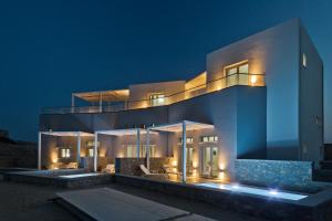 a large white house at night with lights at Kalimera Karpathos Exclusive Villas in Afiartis