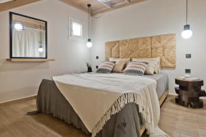 a bedroom with a large bed with a wooden headboard at Kalimera Karpathos Exclusive Villas in Afiartis