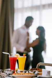 een tafel met twee glazen sap en eten bij Azzeman Hotel in Addis Ababa