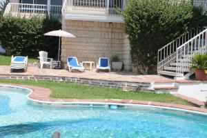 una piscina con sillas y sombrilla en Villa Seaside, en Benicàssim