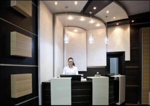 a woman sitting at a counter with a laptop at Apartment 111 at Zoned Apart Hotel & Spa - Apartman 111 u hotelu Zoned in Kopaonik