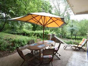 a table and chairs with an umbrella on a porch at Superb holiday home with private garden in Yvias