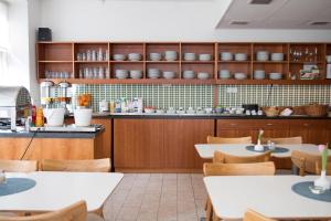 a restaurant with tables and chairs and a counter at Hotell Aston in Karlskrona