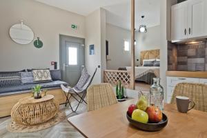 a kitchen and living room with a table with a bowl of fruit at Kalimera Karpathos Exclusive Villas in Afiartis