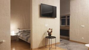 a room with a bed and a television on a wall at LVIV WALL STREET APT in Lviv