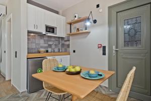 a kitchen and dining room with a wooden table and chairs at Kalimera Karpathos Exclusive Villas in Afiartis