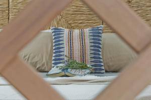 a pillow sitting on top of a bed next to a pillow with a plant at Kalimera Karpathos Exclusive Villas in Afiartis