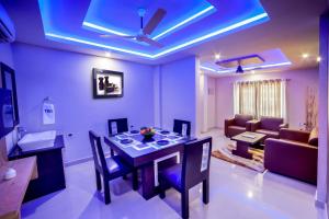 a living room with a dining table and a couch at ALSHIFA TBG RESIDENCY in Perintalmanna