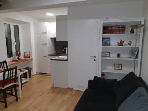 a living room with a couch and a kitchen at Stone Wall Apartment Izola in Izola