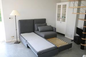een woonkamer met een bank en een stoel bij Studio confortable à la campagne et proche de la ville in Walhain-Saint-Paul