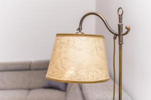 a lamp with a beige shade next to a couch at Apartament Horyzont in Sopot