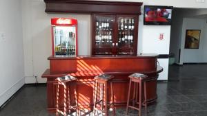 a bar with two stools and a counter with wine bottles at Bravo City Hotel Primavera in Primavera do Leste