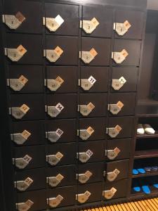 a locker filled with lots of shoes at Guest House Siesta in Tokyo
