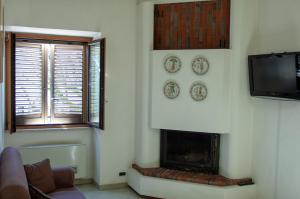 sala de estar con chimenea y TV en Bed & Breakfast Le Piazze, en Cori