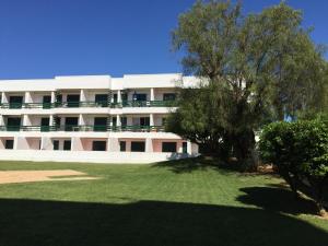 a large white building with a tree in front of it at Peixe and Barco Studio's in Vilamoura