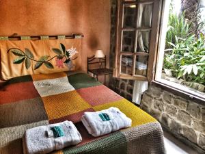 1 dormitorio con 1 cama colorida y toallas. en Posada Ribera del Gualeguaychu en Gualeguaychú
