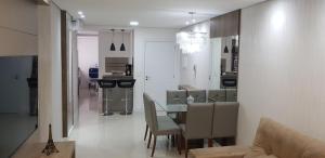 uma sala de jantar com mesa e cadeiras de vidro em Excelente Apto Terraço Verde C/Vista Mar Piscina 3 D em Capão da Canoa