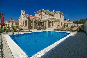 - une piscine en face d'une maison dans l'établissement Luxury Stone Villa Zanelli, à Ližnjan