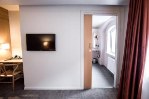 a room with a door with a television on a wall at Hotel Bethel in Copenhagen
