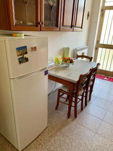 uma cozinha com uma mesa e um frigorífico branco em Fra il MARE e la SILA em Cerenzia