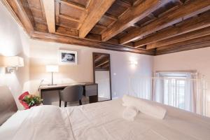 um quarto com uma cama e uma secretária com uma cadeira em Scala Apartments Via Borgo Pinti em Florença