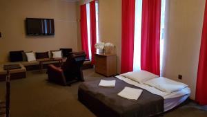 a hotel room with a bed and red curtains at Sarenka in Miedzygorze