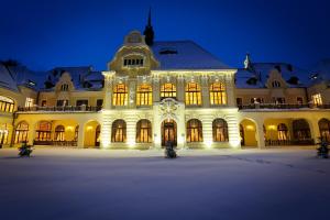 マリアーンスケー・ラーズニェにあるRubezahl-Marienbad Luxury Historical Castle Hotel & Golf-Castle Hotel Collectionの夜間の時計付きの白い大きな建物