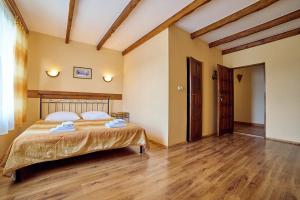 1 dormitorio con 1 cama y suelo de madera en Rancho, en Mała Nieszawka
