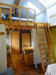 a room with a bunk bed and a table and a desk at Le Fournil Gîte Rural in Trois-Ponts