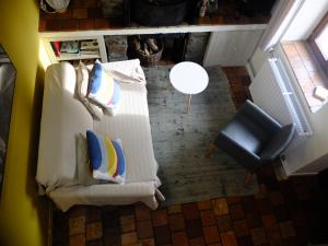 eine Aussicht über ein Wohnzimmer mit einem Sofa und einem Stuhl in der Unterkunft Le Fournil Gîte Rural in Trois-Ponts
