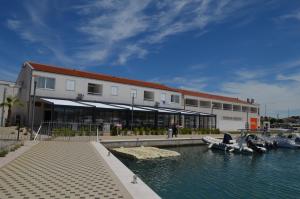 a building with a marina with boats in the water at Apartments Pirovcanka in Pirovac