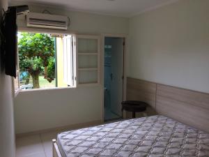 a bedroom with a bed and a window at Recanto da Enseada - Condomínio Via Marina in Ubatuba +22 photos