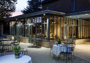 a group of tables and chairs in front of a building at Hôtel La Hoirie in Sarlat-la-Canéda