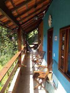 a porch with chairs and a hammock on it at Chalés de Analuz in Visconde De Maua