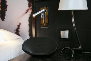 パリにあるホテル ド セーズのベッドルーム(テーブル付)、ベッドの横のランプが備わります。